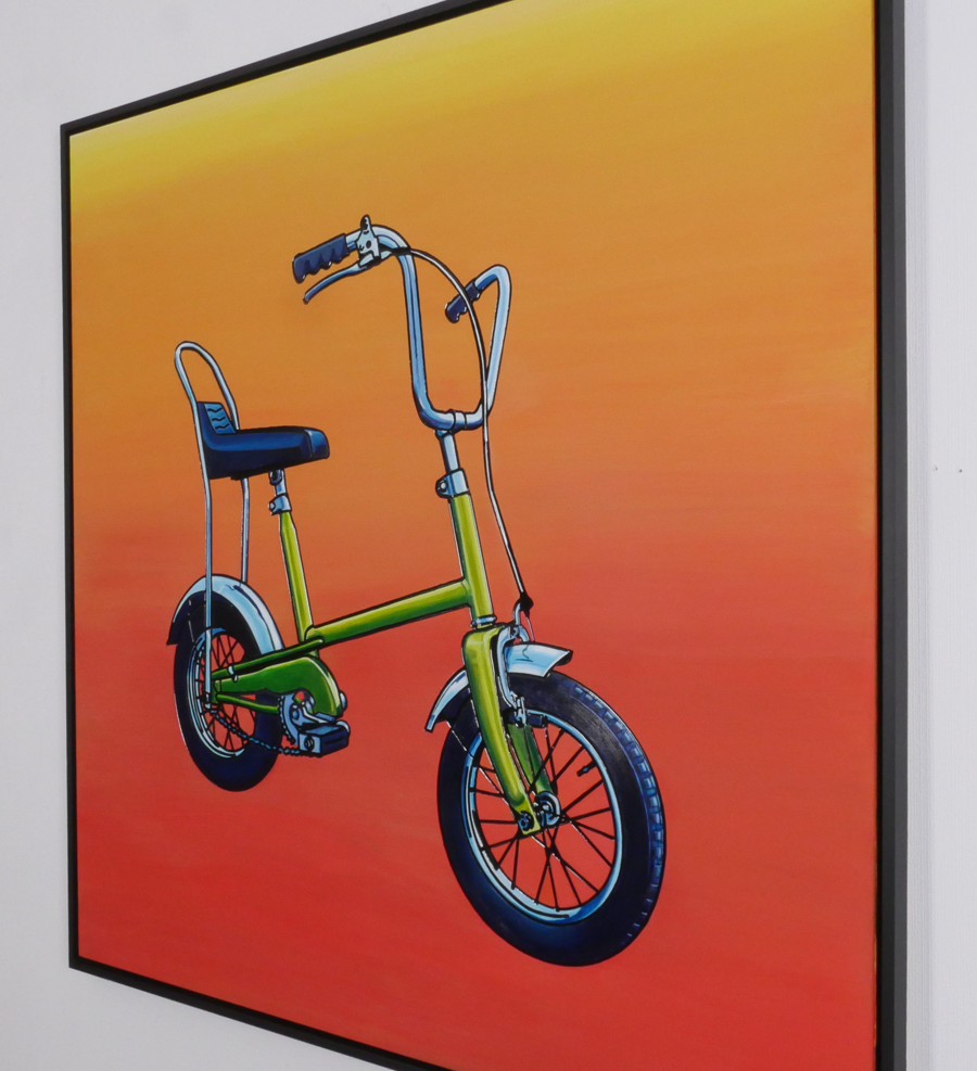 First Bike in its black frame, seen at an angle on the studio wall